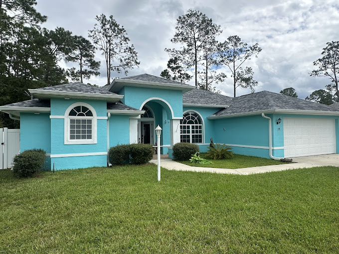 A blue house with a white fence in front of it