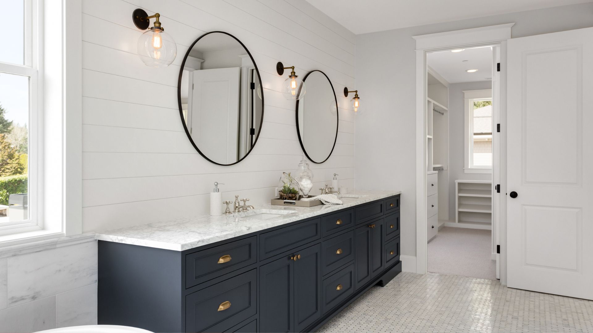 A bathroom with two mirrors and a double sink