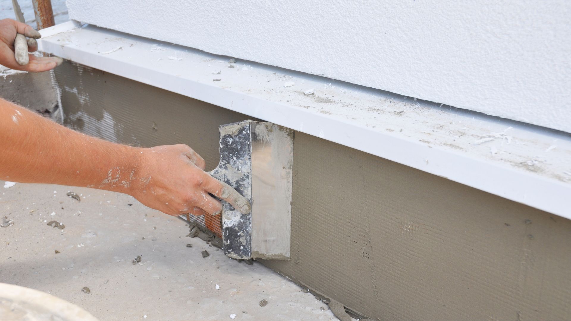 A person is working on a window sill