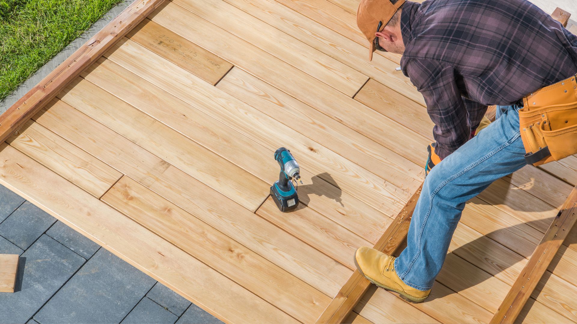 A man is working on a wooden deck