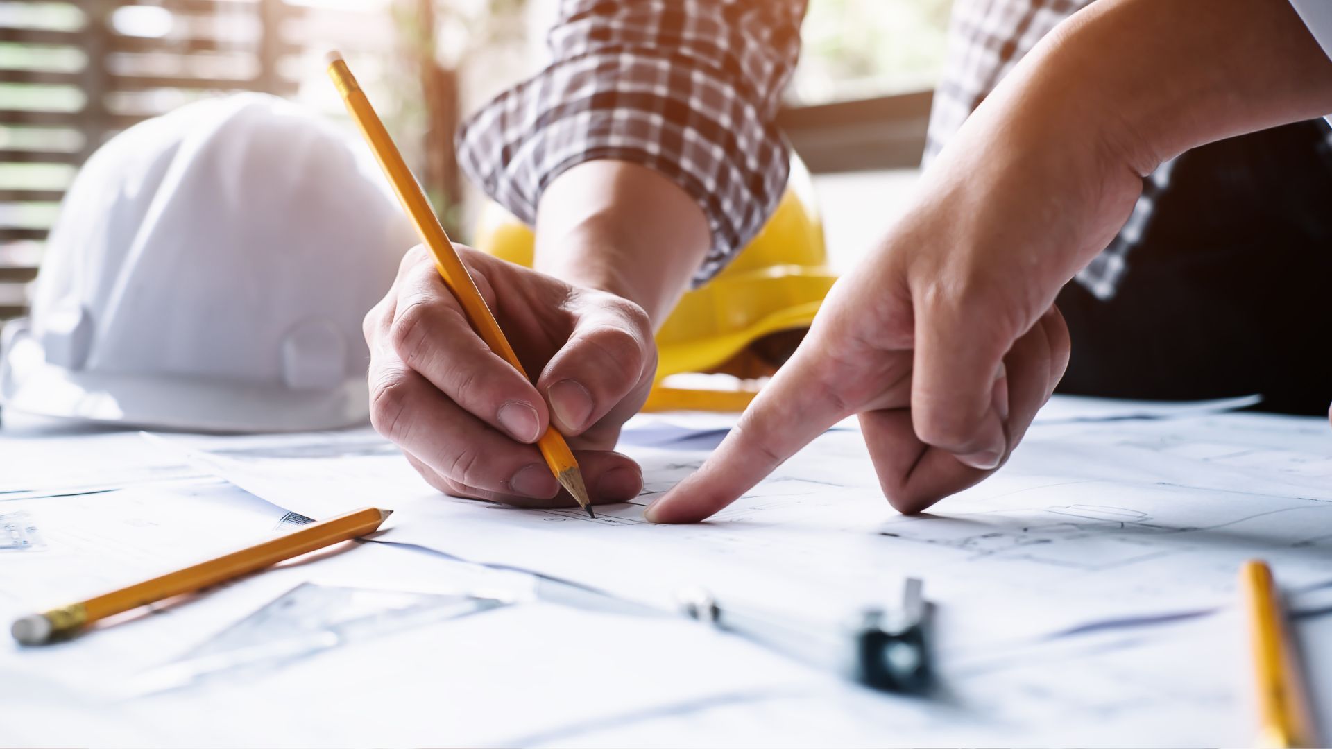 A man is drawing on a piece of paper with a pencil