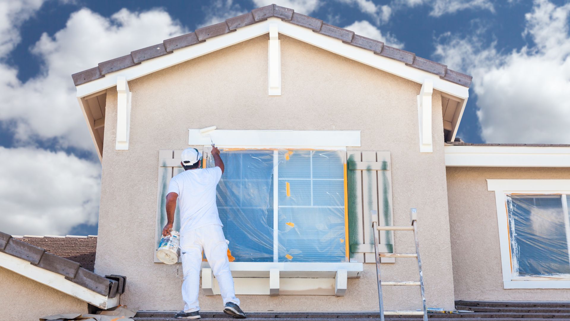 A man painting the outside of a house