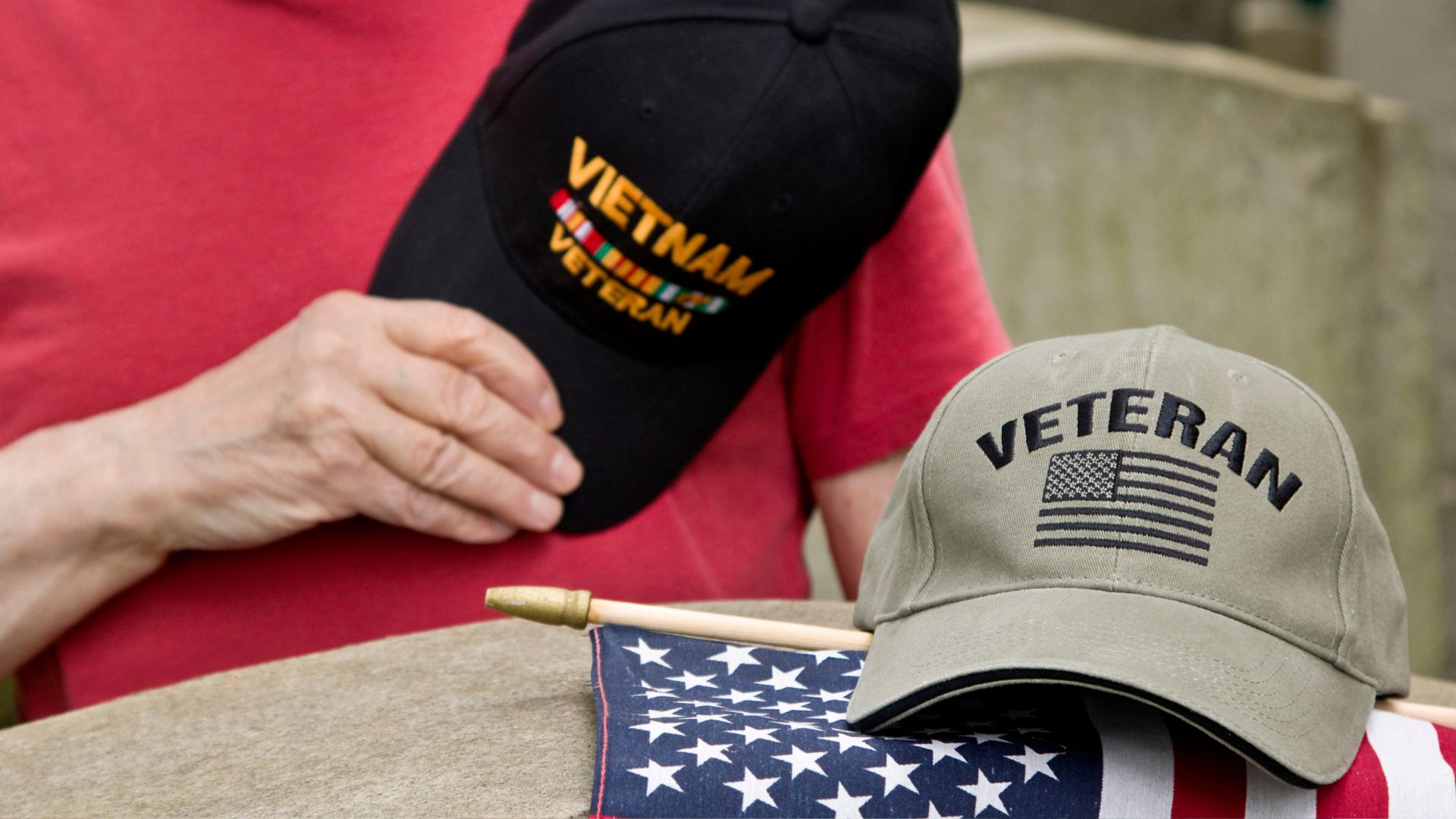 A veteran hat sits on top of an american flag